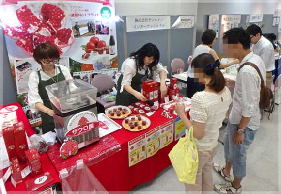 来場したご夫婦に石榴の滴を試飲してもらっています